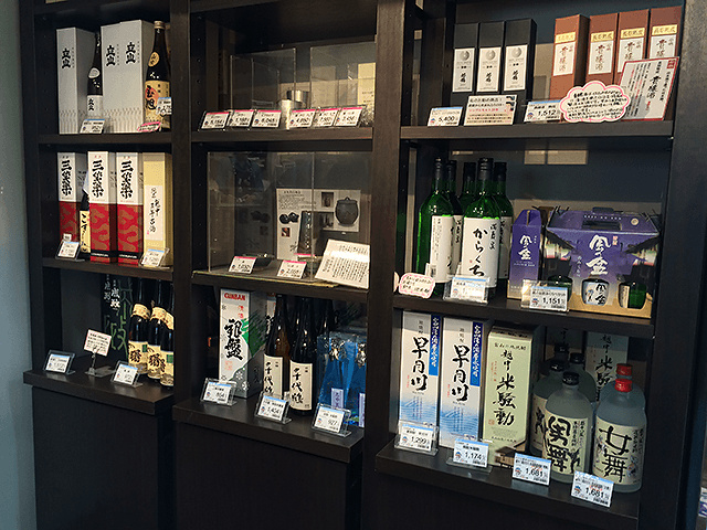 壁一面に造りつけられた陳列棚には地酒がずらり！いきいき富山館。